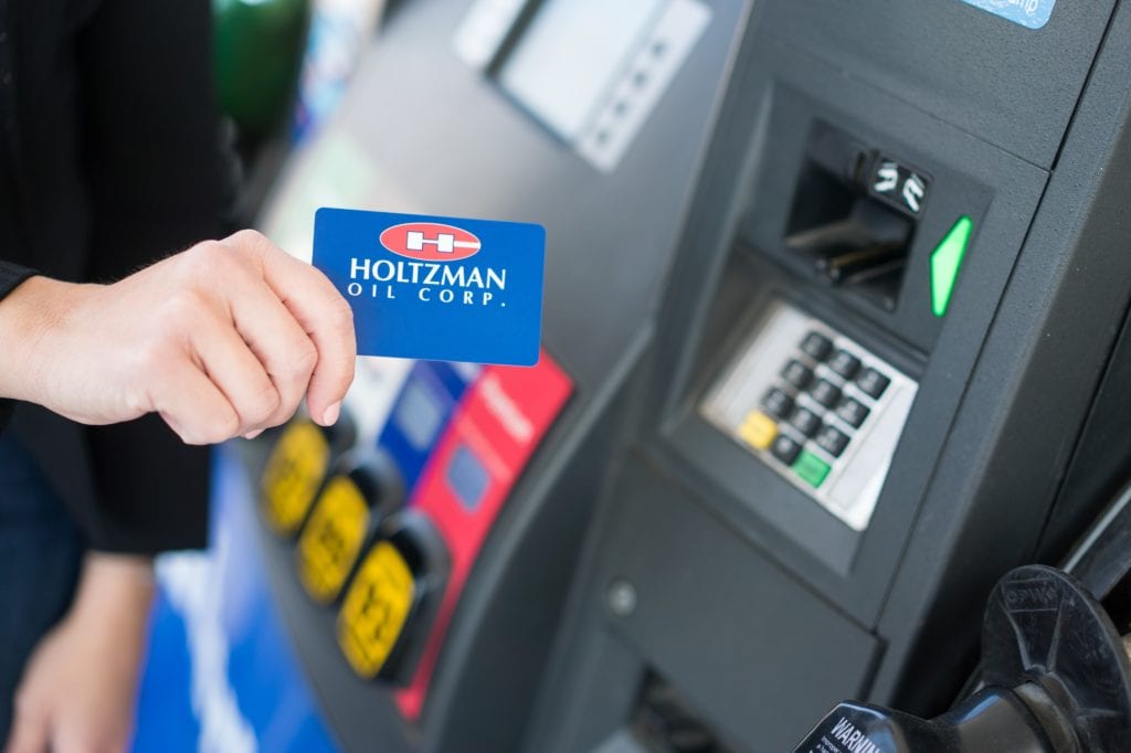Holtzman Oil Corporation cards at a gas pump.